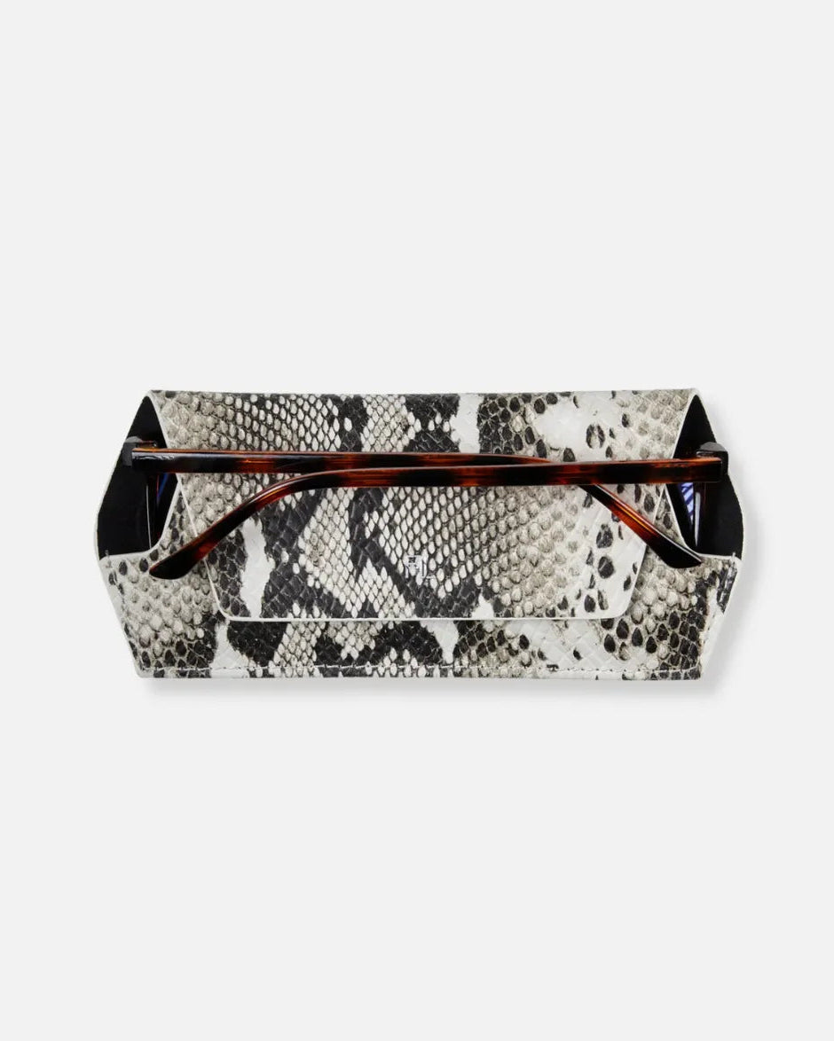 A rectangular eyeglasses case with a black and white snakeskin pattern, featuring a front pocket and a top handle holding tortoiseshell acetate sunglasses, shown against a light gray background.