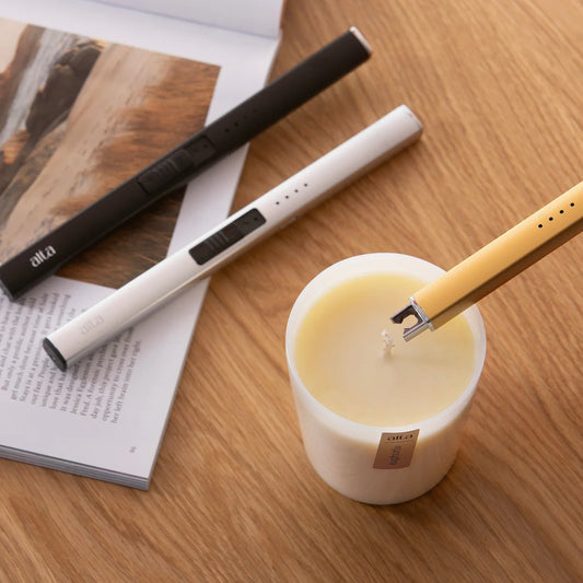 Sleek silver flameless lighter igniting a candle