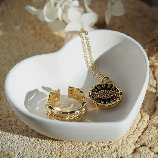 Close-up heart trinket bowl with gold jewellery inside