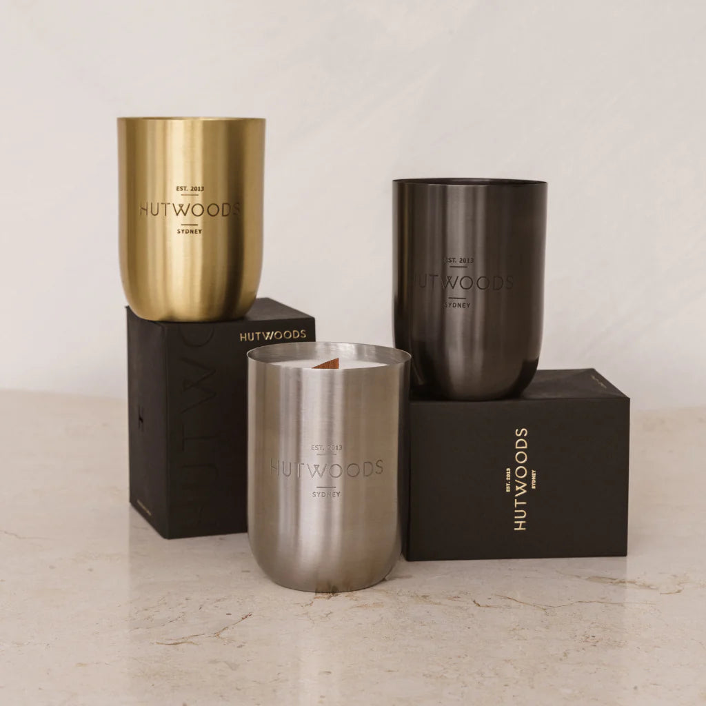 A collection of all 3 container colours for Hutwoods signature metal vessel 80+ hour candles. Gold, black and silver and they come in a stylish mat black box.