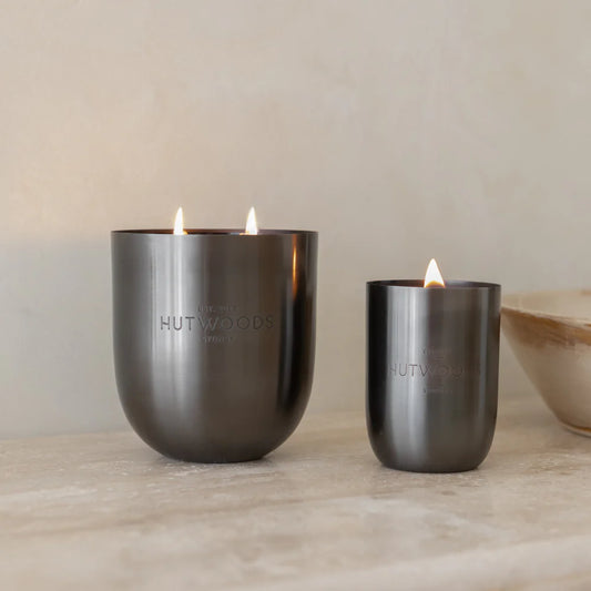 Two of Hutwoods signature black wood wick candles: XL (extra luxe) and small.