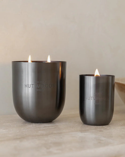 Two of Hutwoods signature black wood wick candles: XL (extra luxe) and small.