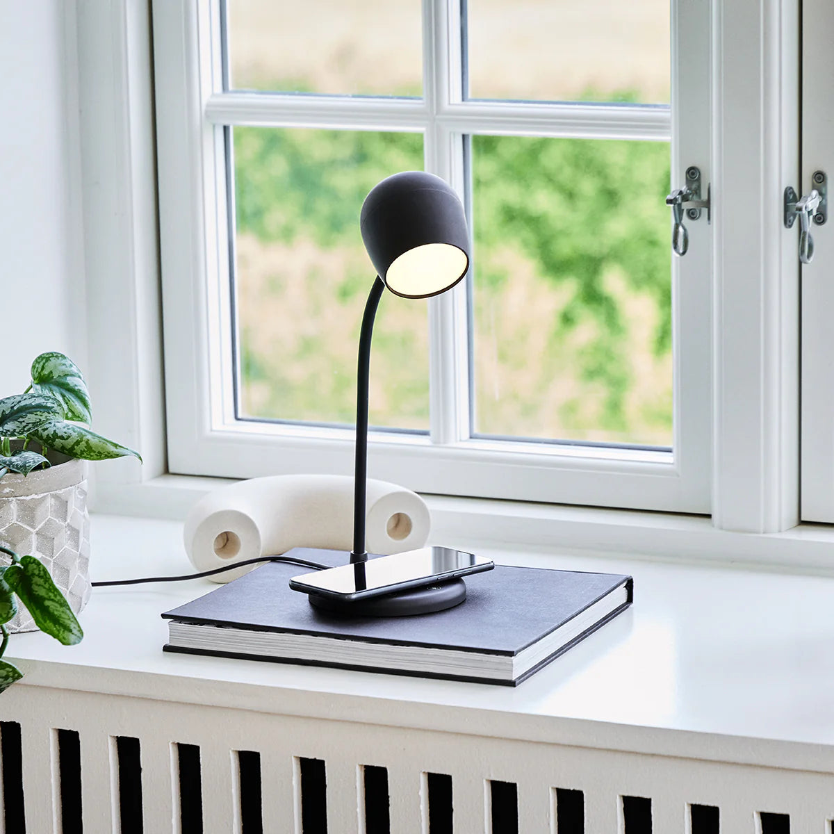 Modern desk setup featuring Kreafunk Ellie White Lamp charging a phone