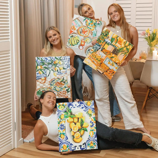 A group of friends displaying their finished Paint Like Frida Paint By Numbers artworks.