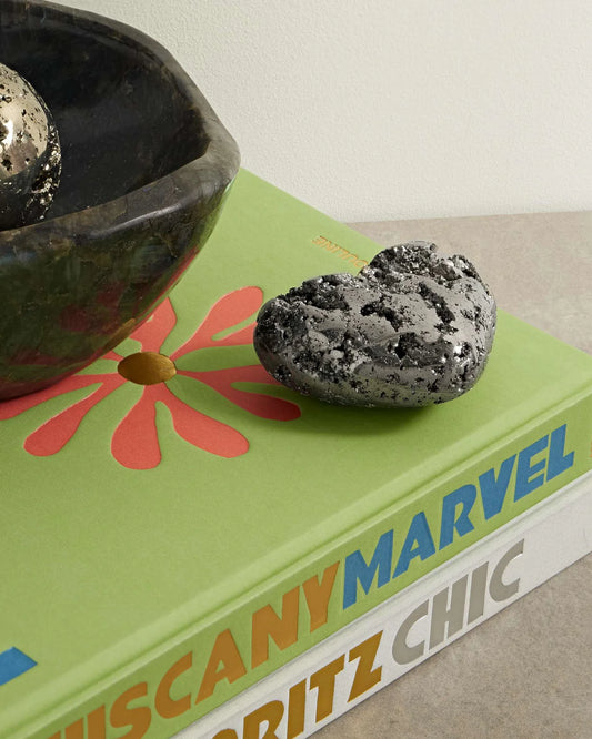 Pyrite Heart displayed on a pile of books.