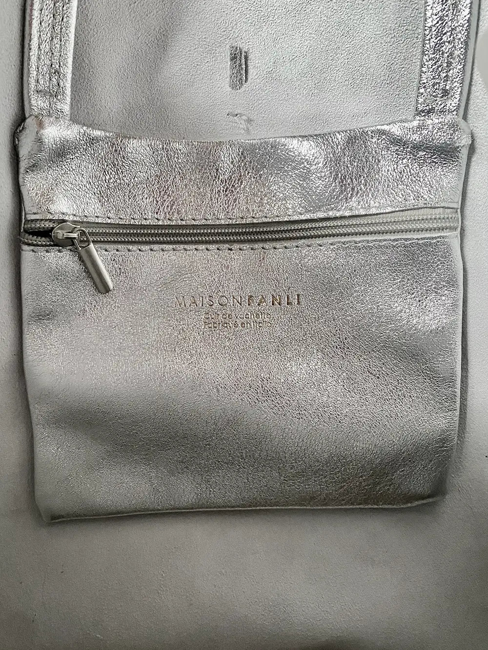 Internal pocket of the silver metallic Maison Fanli large tote bag to keep small things secure and easy to find.