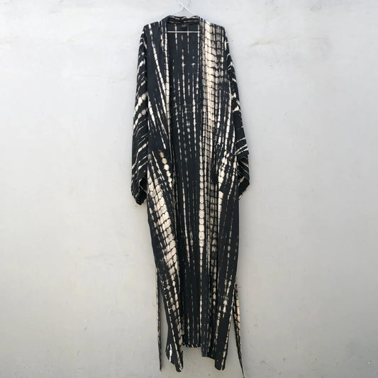 Oversized bamboo robe in batik tie-dye monochrome black hanging on a coat hanger... it comes with a carry bag made from the same fabric.