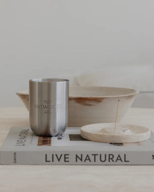 Hutwoods 350g/80 hour candle displayed on a marble tabletop
