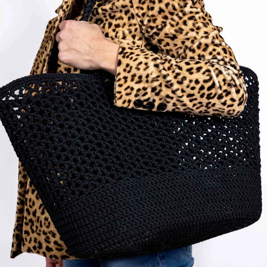 A model holding the French-Style Black Crochet Basket Beach Bag to give you an idea of scale. It's a great size and fits loads of stuff.