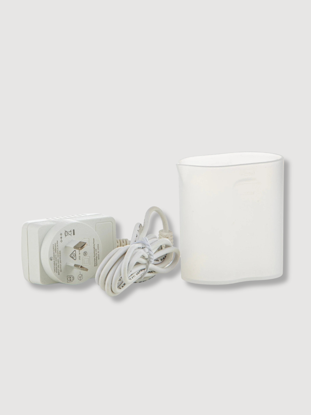 White ceramic ultrasonic diffuser accessories: plug and a jug to fill it up with fresh water.