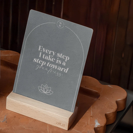 Alta Weekly Wellbeing motivational card with quote on a wooden stand against a dark background. Keep your mindfulness practice front of mind by keeping it in front of you.