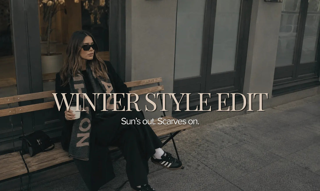 Woman enjoying a slow winter morning styled with a soft wool scarf, oversized sunglasses and timeless winter accessories from Hunted + Co. inspired by café culture and relaxed seasonal dressing.
