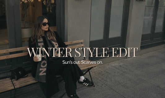 Woman enjoying a slow winter morning styled with a soft wool scarf, oversized sunglasses and timeless winter accessories from Hunted + Co. inspired by café culture and relaxed seasonal dressing.