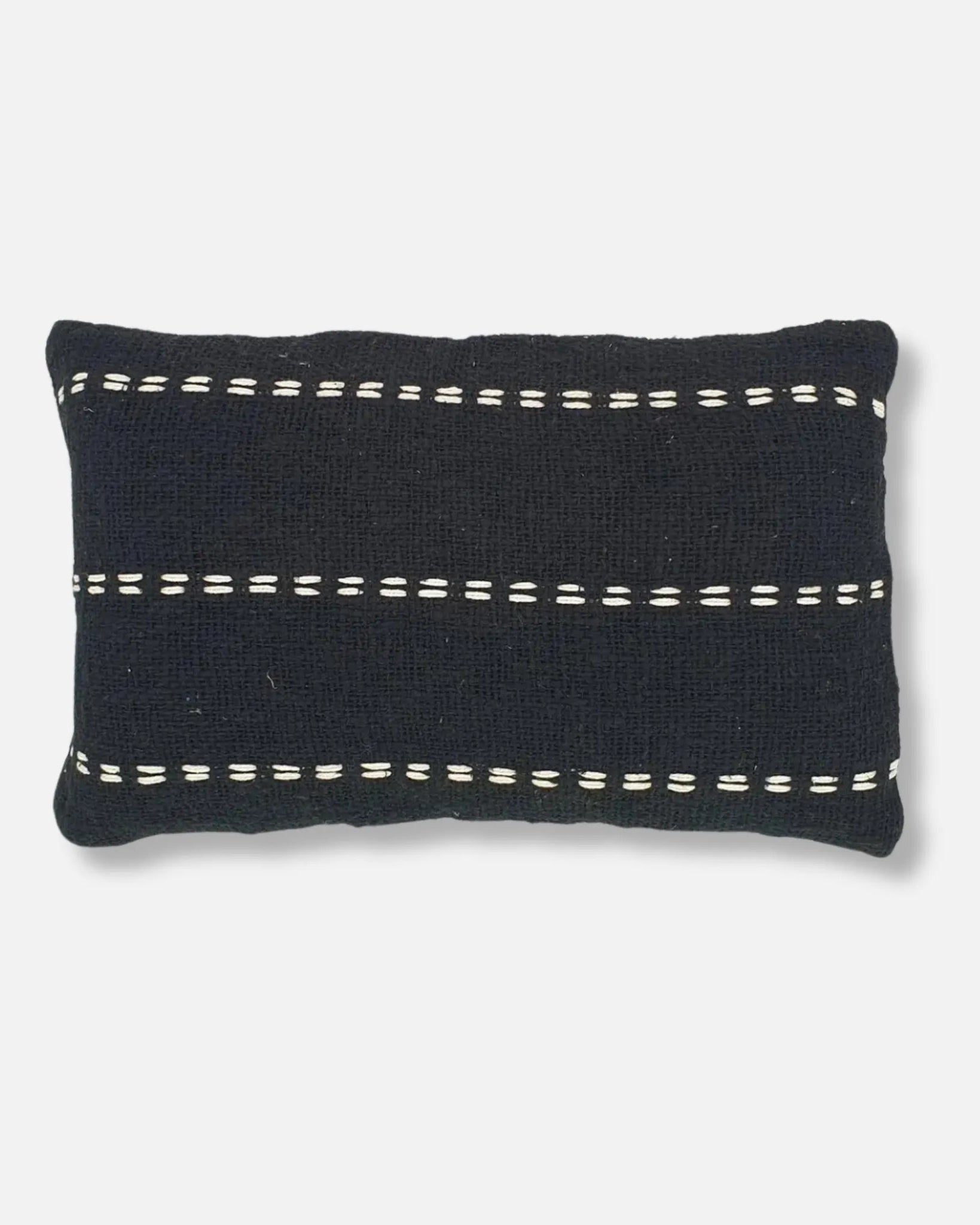 A rectangular black knit throw pillow with horizontal white dashed stitch accents, shown against a light grey background.