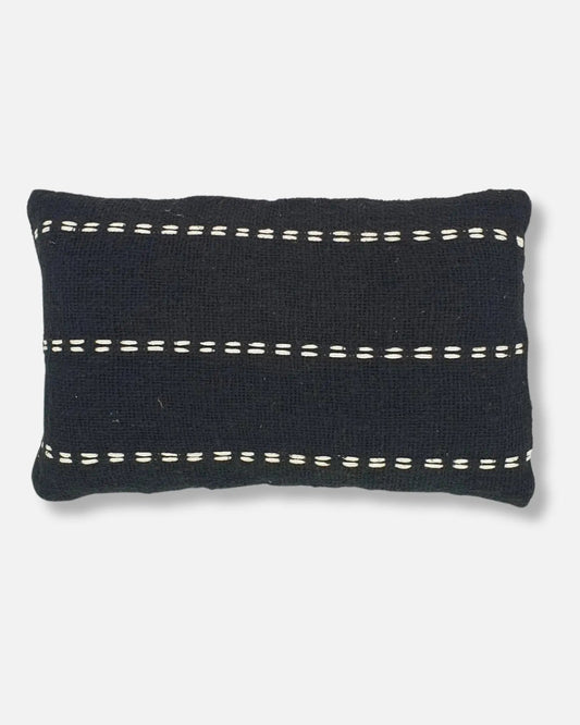 A rectangular black knit throw pillow with horizontal white dashed stitch accents, shown against a light grey background.