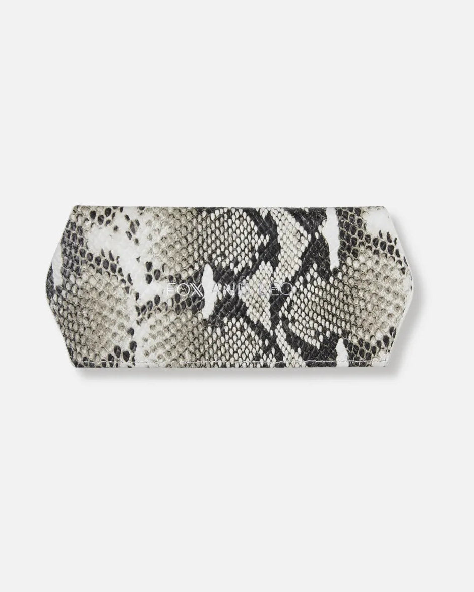 A hexagonal clutch bag featuring a black and white snakeskin pattern, displayed on a clean, light gray background.