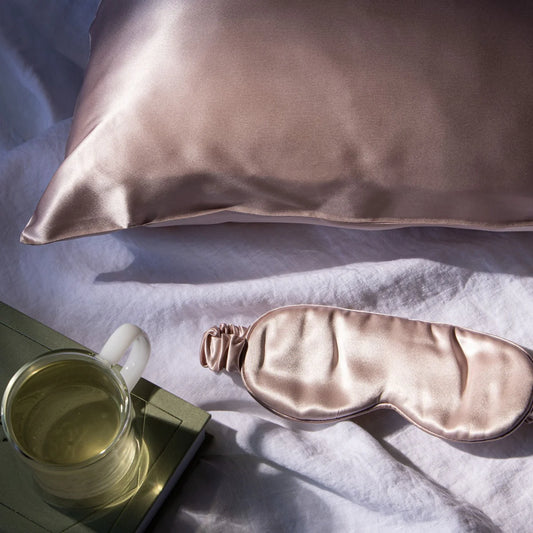 Luxurious shell pink silk sleep mask on linen