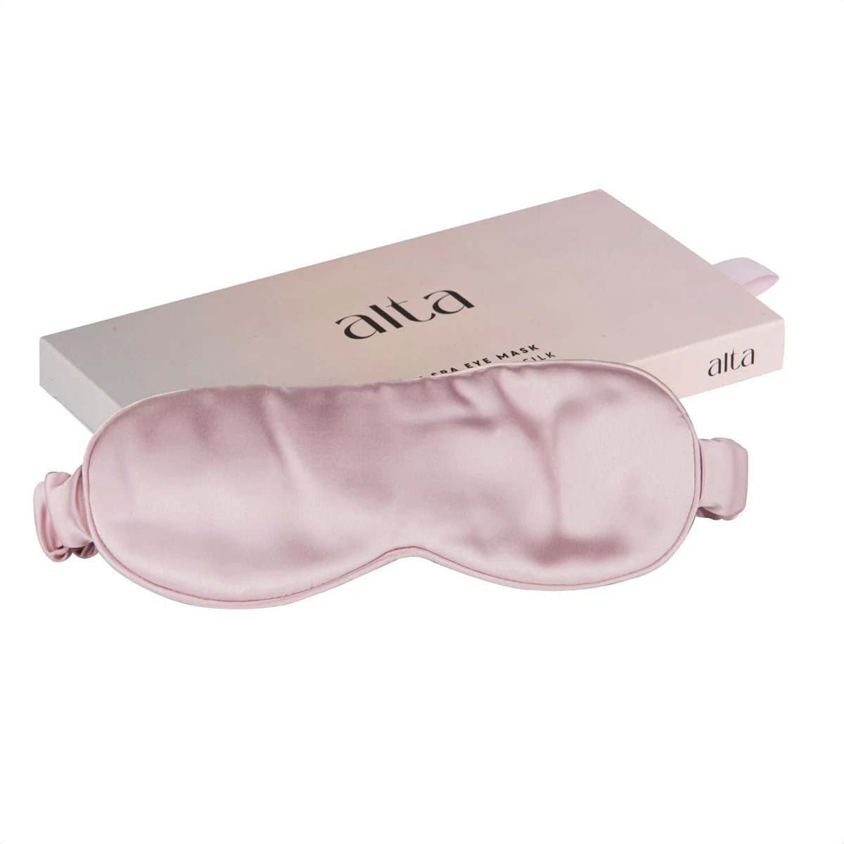 Shell pink silk eye mask for luxury spa sleep sitting on the box it comes in.