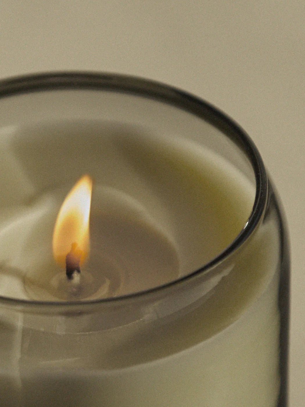 An up close shot of the Ashley and Co Waxed Perfume Candle in the Tui and Kahili scent burning peacfully 