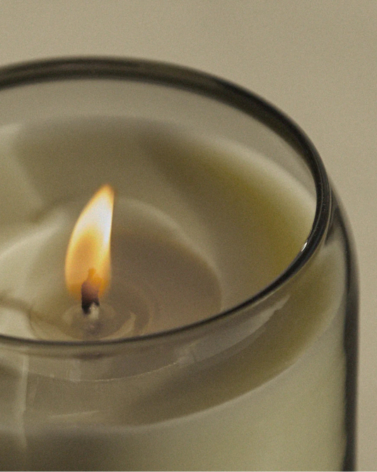 An up close shot of the Ashley and Co Waxed Perfume Candle in the Tui and Kahili scent burning peacfully 