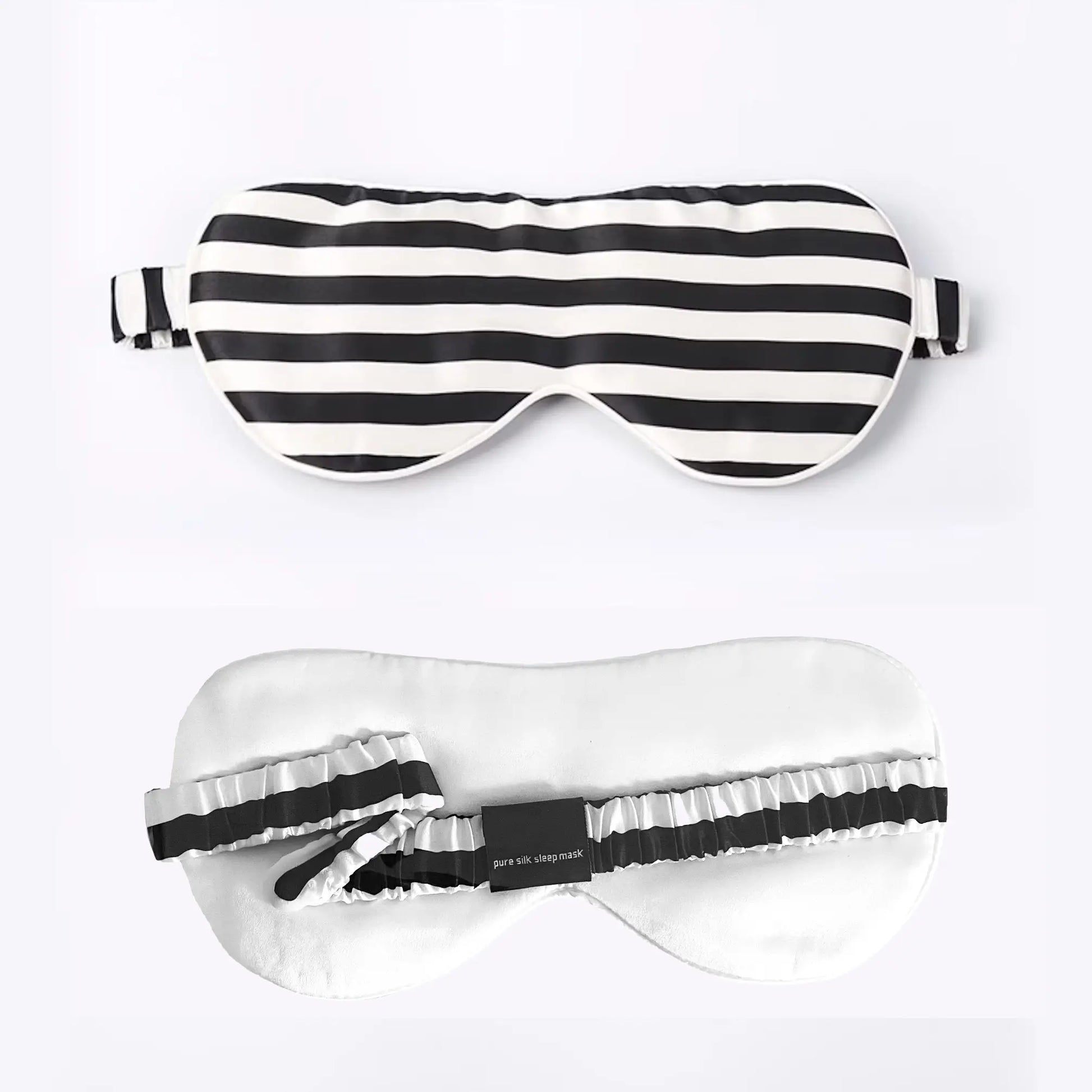 Silk sleep mask in black and white stripes laid flat showing front and back