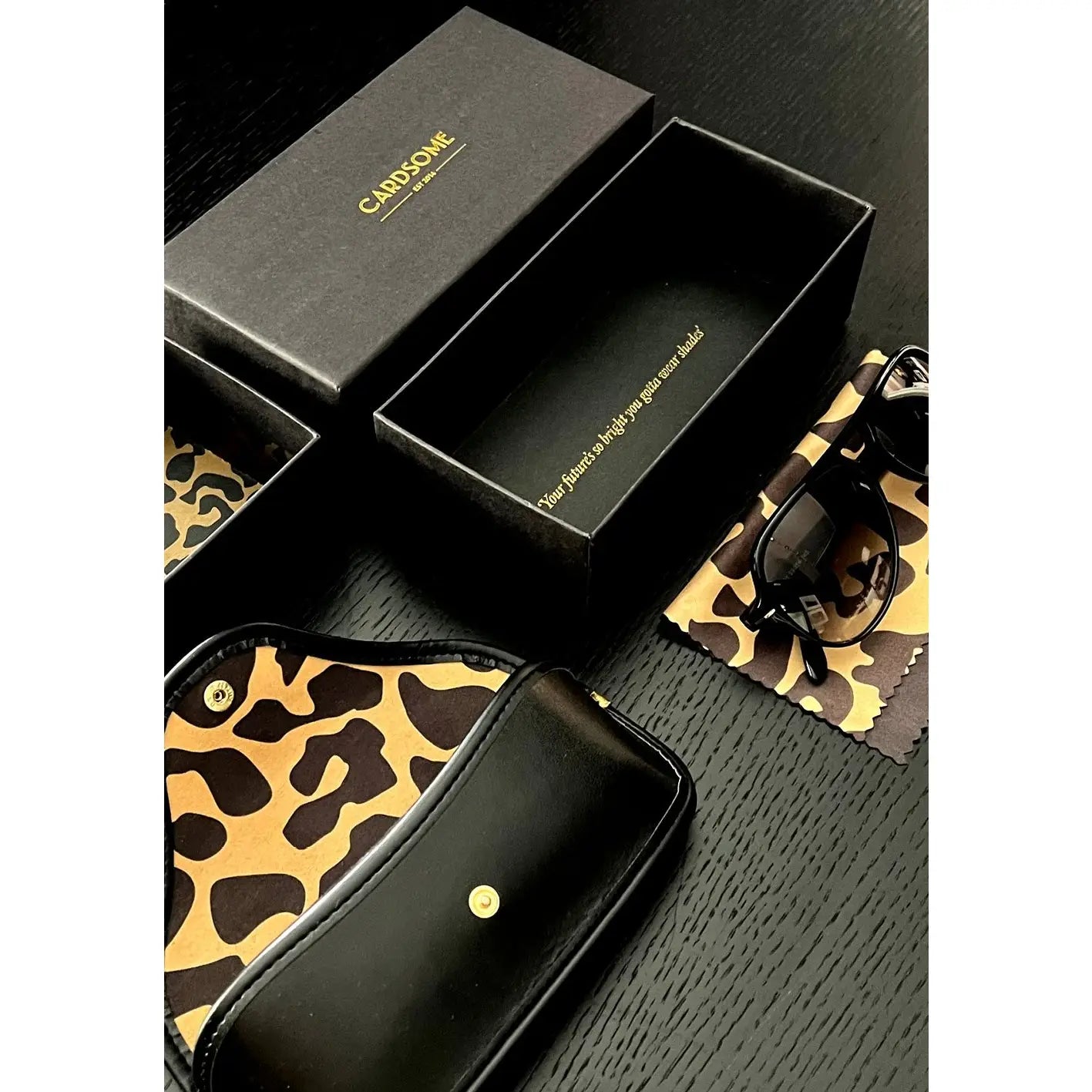 A flat lay of the awesome sunglasses case + animal print cleaning cloth that comes with your Betty Boyfriend sunglasses. 