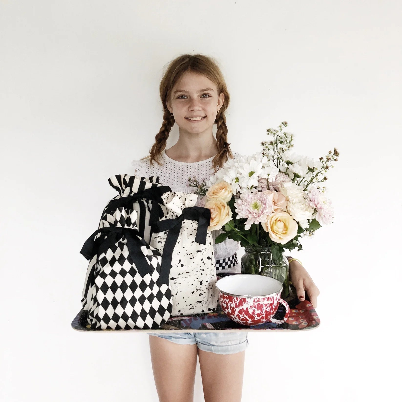 Collection of chic reusable gift wrap bags with recycled PET grosgrain ribbon displayed on a tray