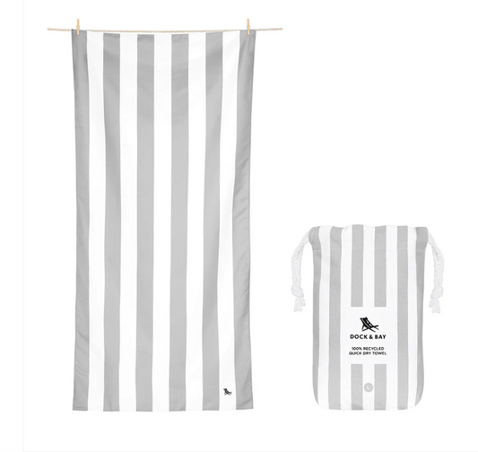 Light grey and white striped microfibre beach towel on sand