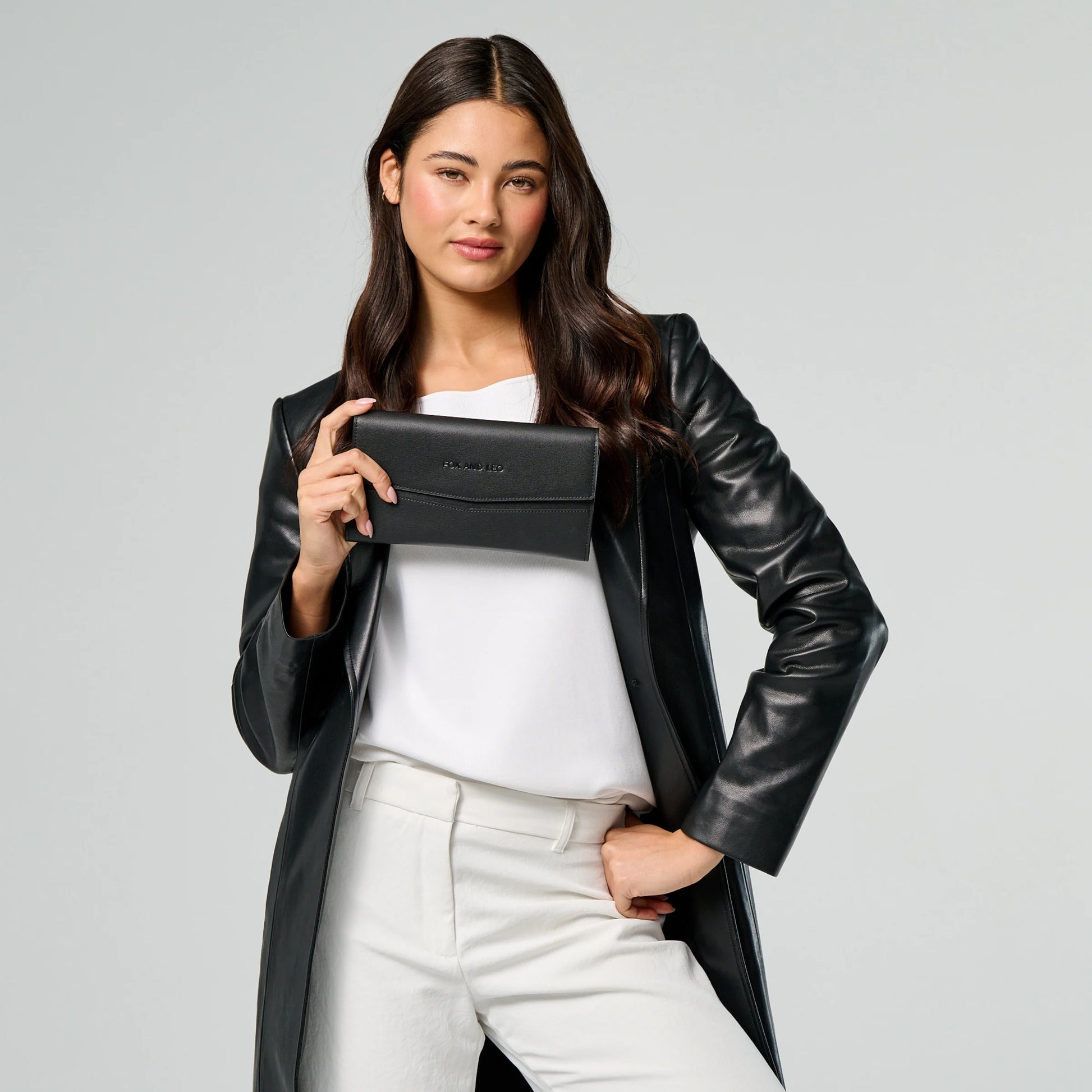 A woman holding The Traveller wallet in black.