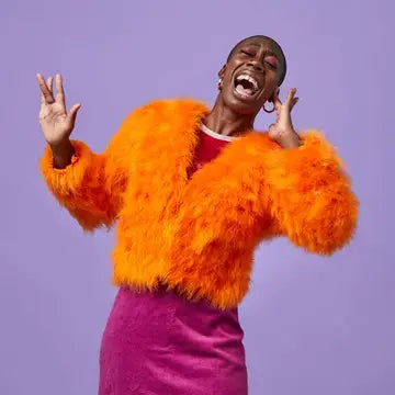 A brightly dressed woman laughing and having fun playing Fool!