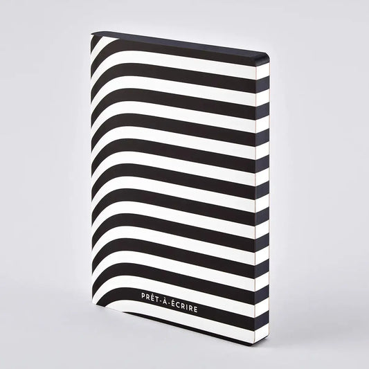 Nuuna Prêt-À-Écrire notebook standing up against a white background showing off its graphic black and white stripe design.