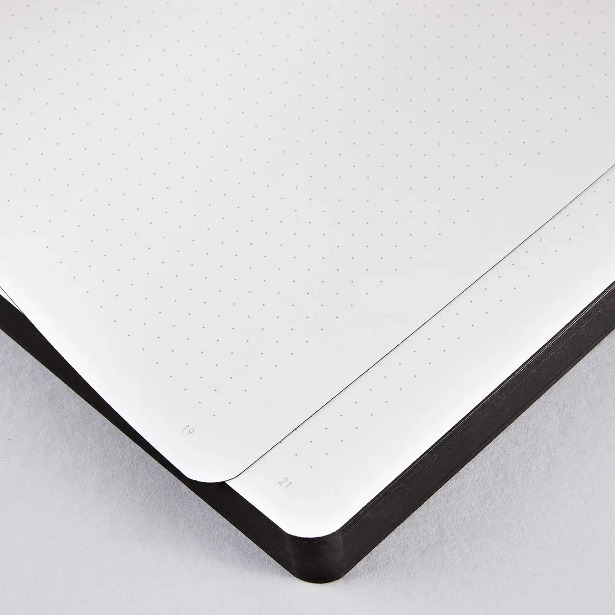 View of the inside of the Nuuna Rebel with a Cause notebook with it's dot grid pages and solid black page edges. Tres cool.