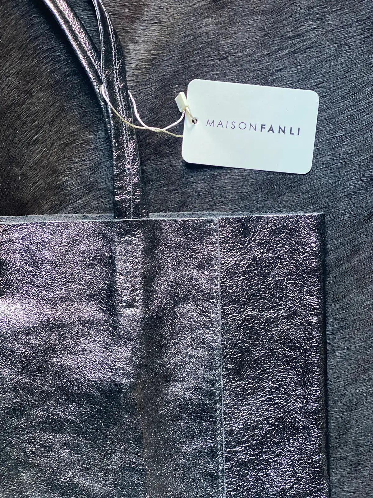 Close up detail of the Maison Fanli Large Tote in Metallic Grey highlighting the minimalist design, stitching and the texture of the leather. Gorgeous. 