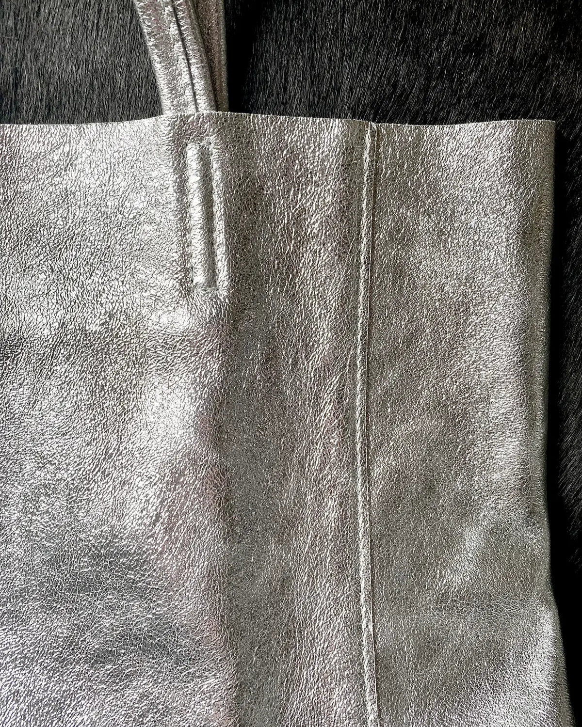 Close up detail of the Maison Fanli Large Tote in Metallic Silver highlighting the minimalist design, stitching and the texture of the leather. Gorgeous. 