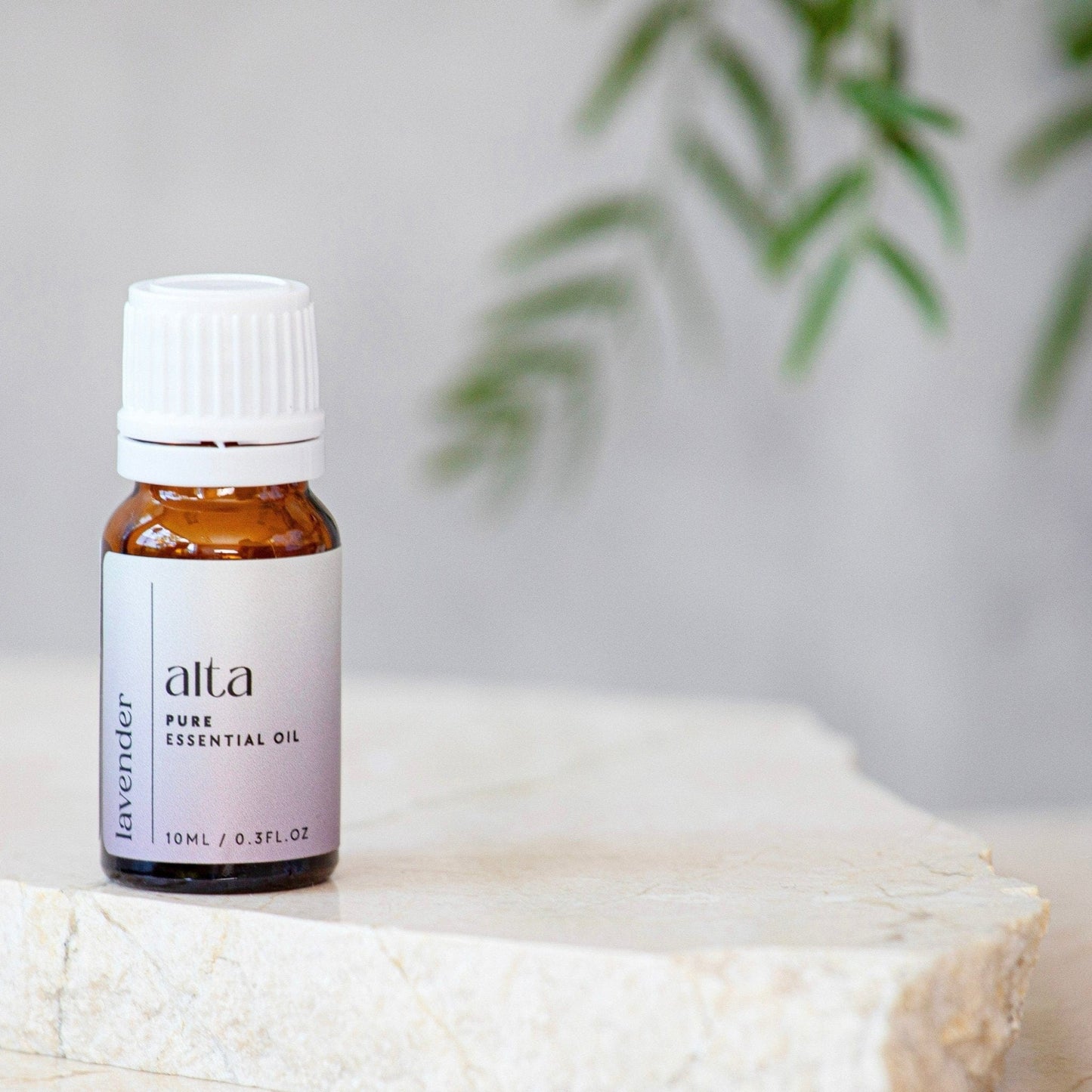 Alta Pure Essential Oil in Lavender on a stone bench with an out of focus backbround.