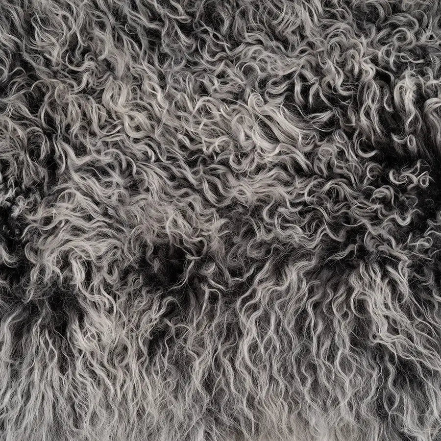 Close up of the Hides of Excellence Charcoal and White Mongolian sheepskin lumbar cushion to highlight the colour variation (charcoal at the base through to light grey tips) and how soft it looks (and feels).
