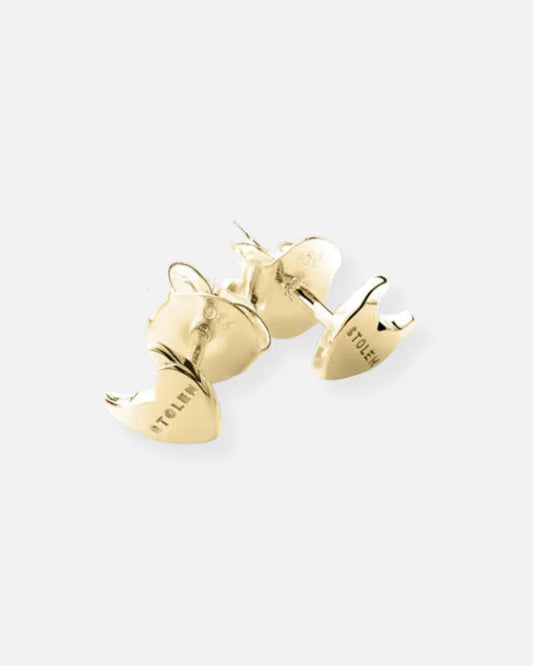 A pair of gold-colored ceramic stud earrings shaped like small animal paws, shown on a light gray background. The brand name 'STOLENS' is engraved on the side of the paw charms.