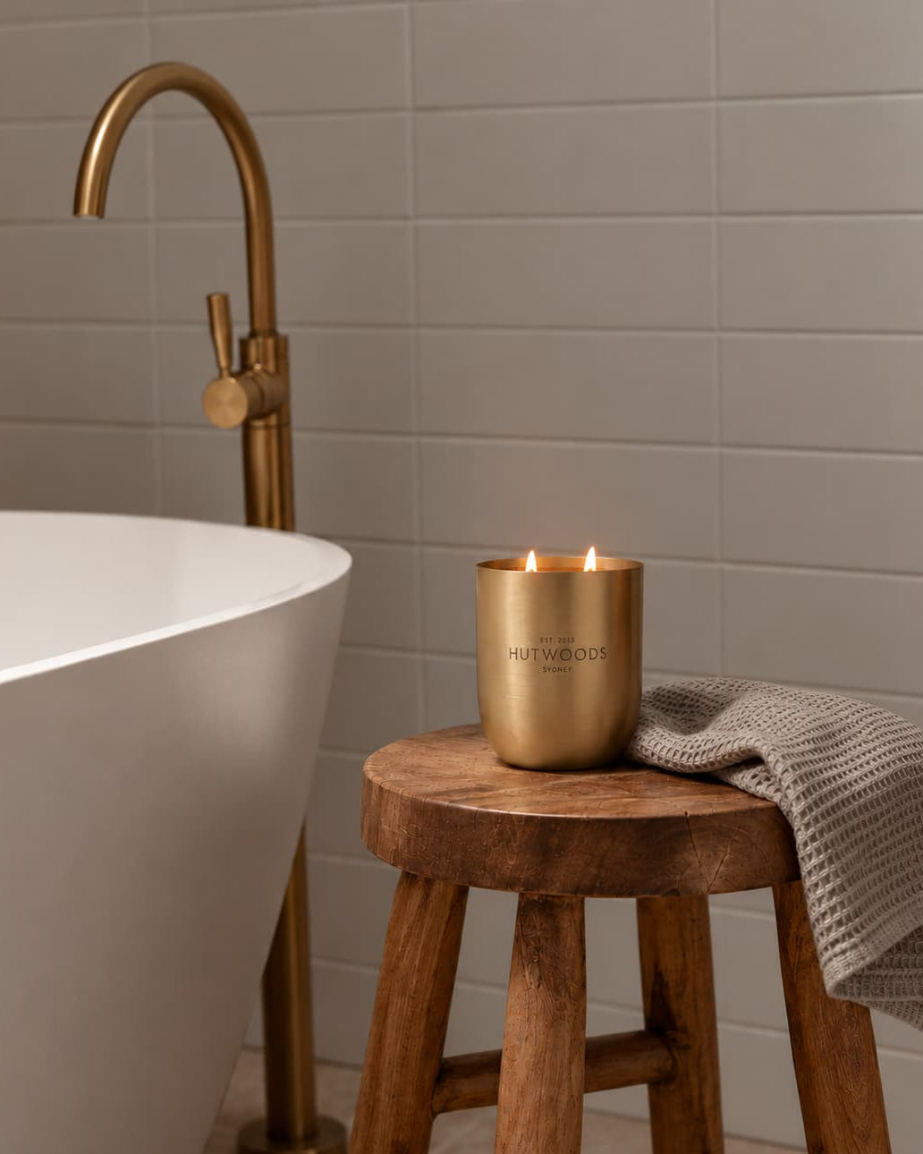Scandinavian Bath setting with Brass Metal Hutwood XL Candle glowing