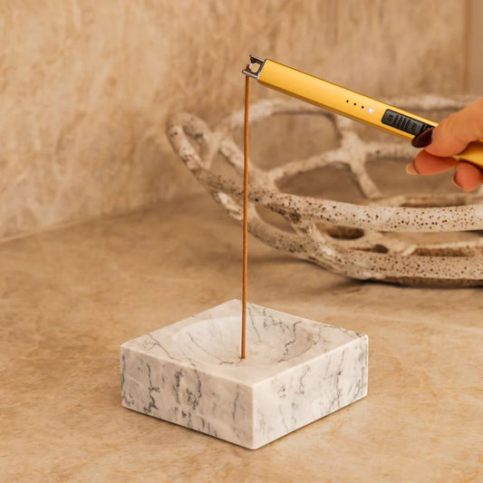 A lighter being used to light an incense stick on the Marble Incense Holder without the Lava Stones... being used as an incense holder.