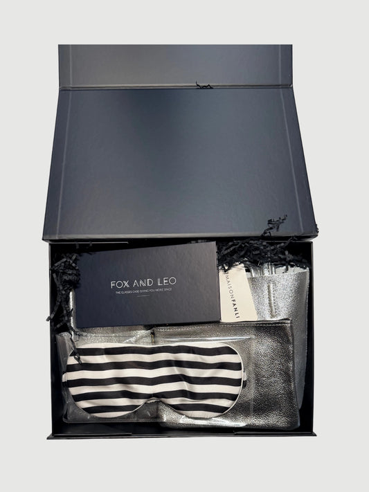 Open Luxe Wanderer gift box showing leather tote, silk sleep mask, metallic pouch and glasses case inside