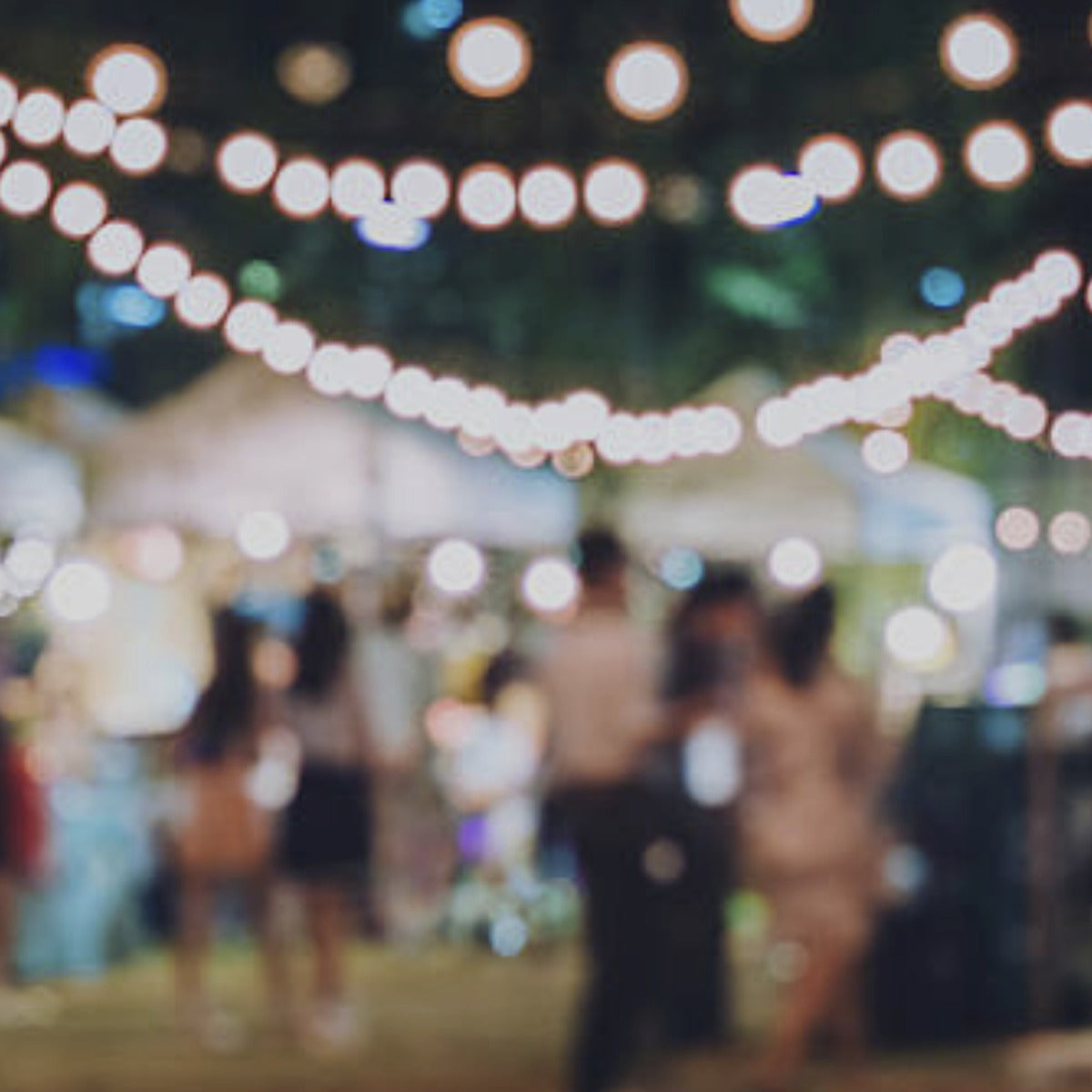 People gathered under string lights at an evening celebration